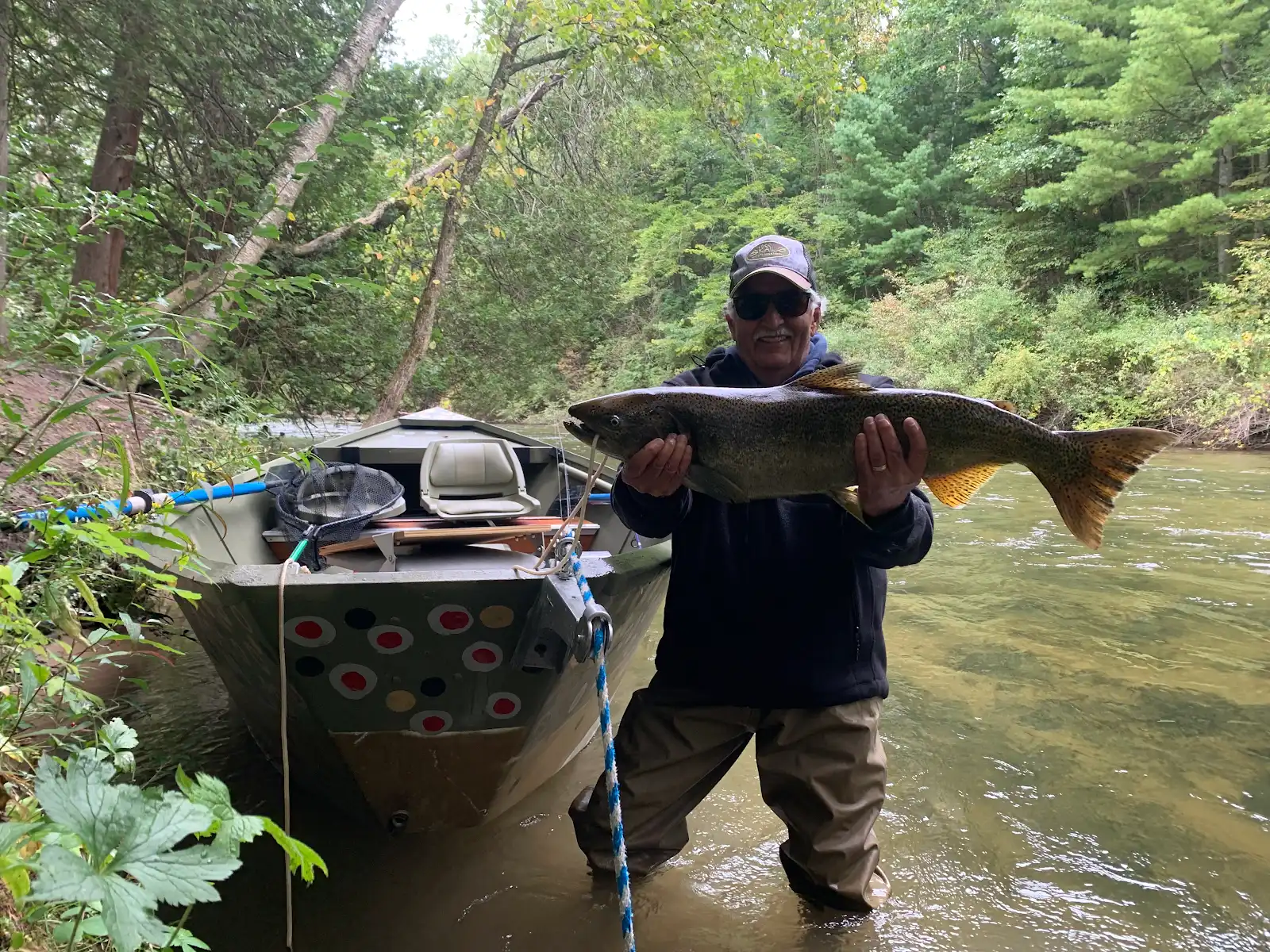 Angler with a large Chinook salmon beside the drift boat